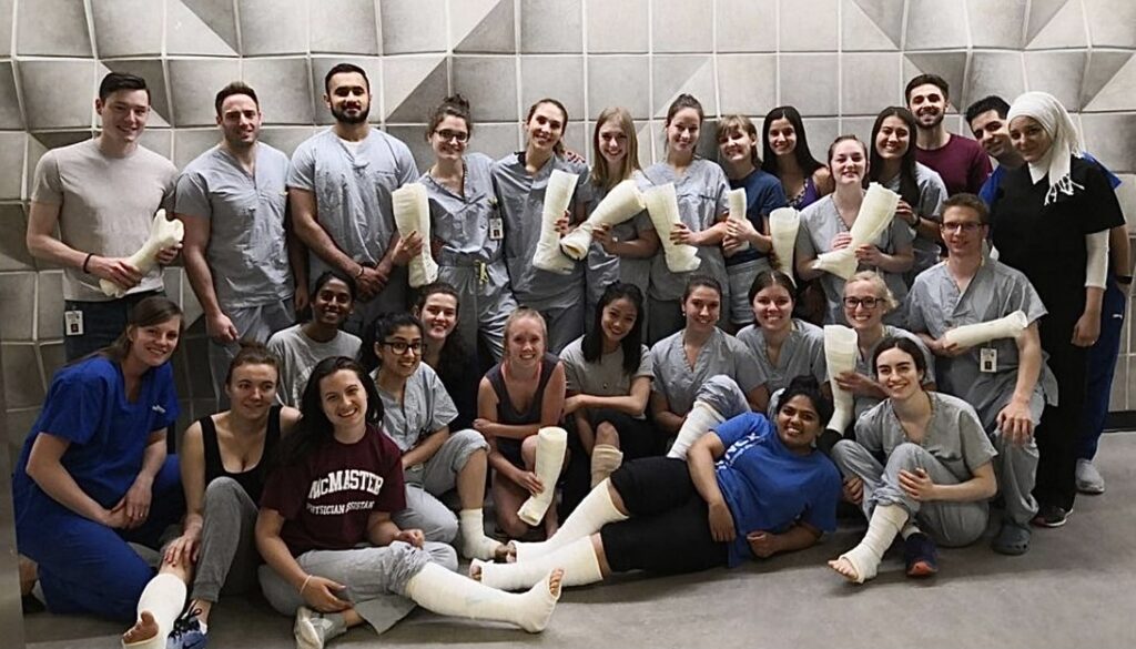 A group of students with casts on their legs and holding casts